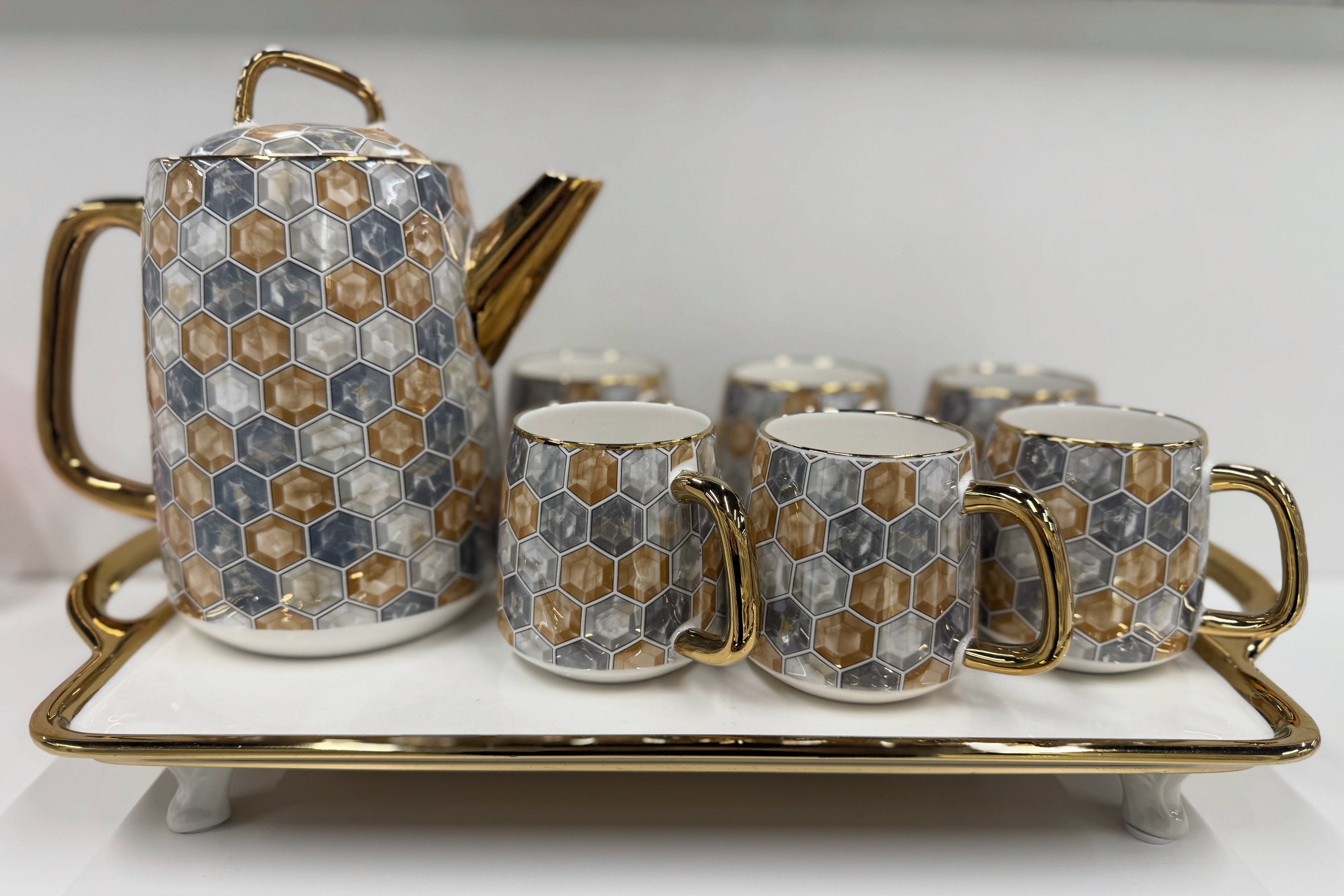 Ceramic tea set with hexagonal pattern on a white surface